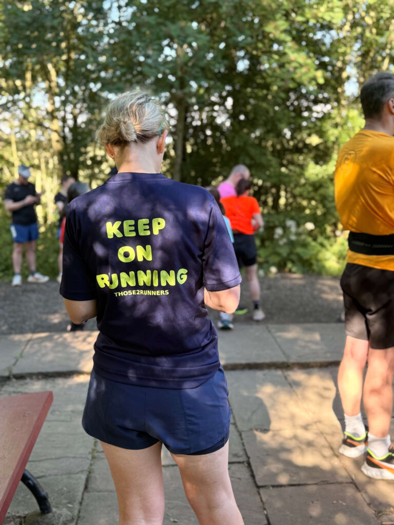 Kayleigh at parkrun showing the back of her Keep On Running t-shirt